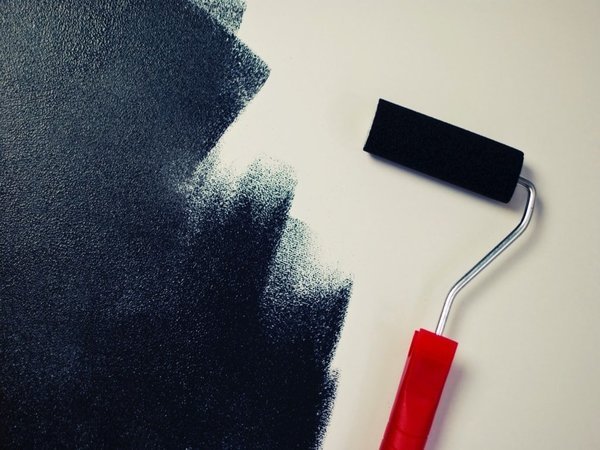 Roller painting a wall