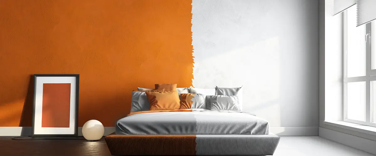 Modern bedroom with split orange and white walls, stylish decor, and contemporary design elements.