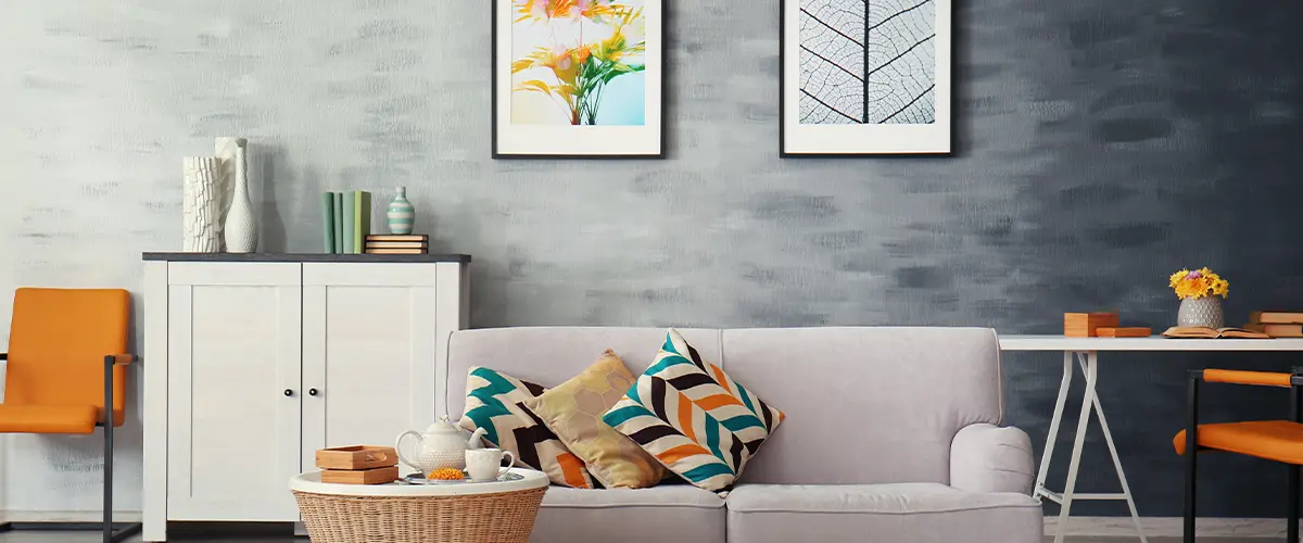 Stylish living room with a gray textured wall, vibrant pillows, and decor.