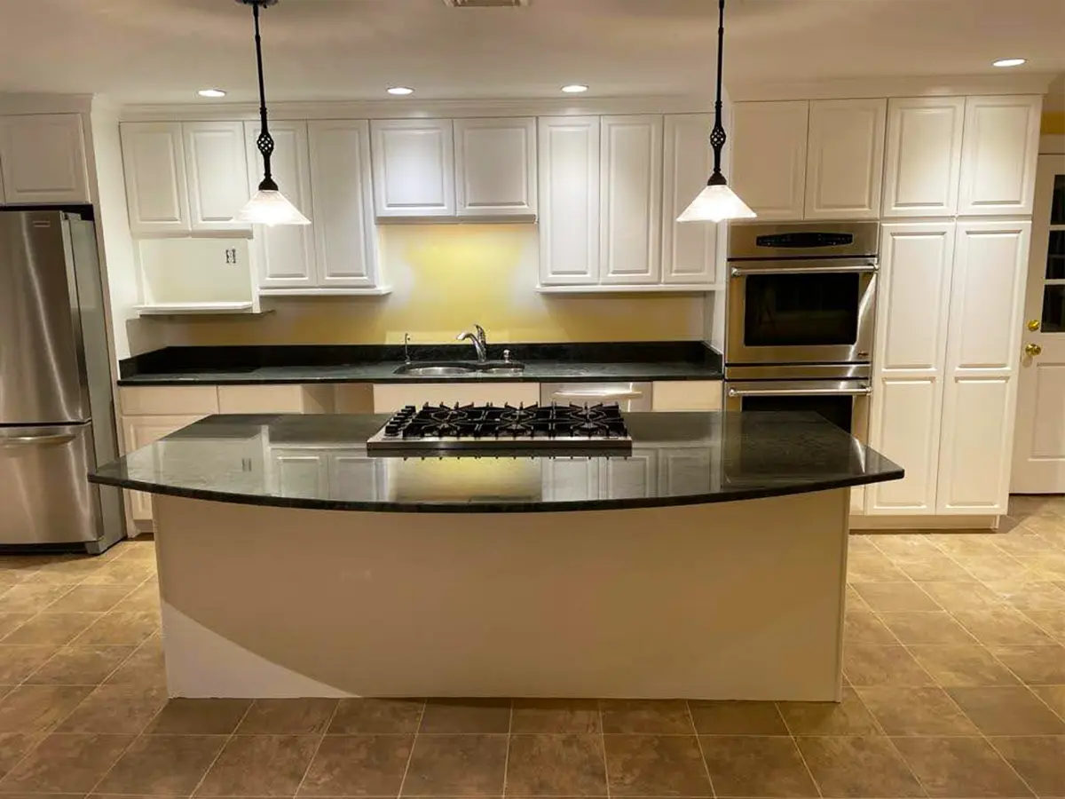 Freshly painted white kitchen cabinets and black countertops creating a bright, modern look.