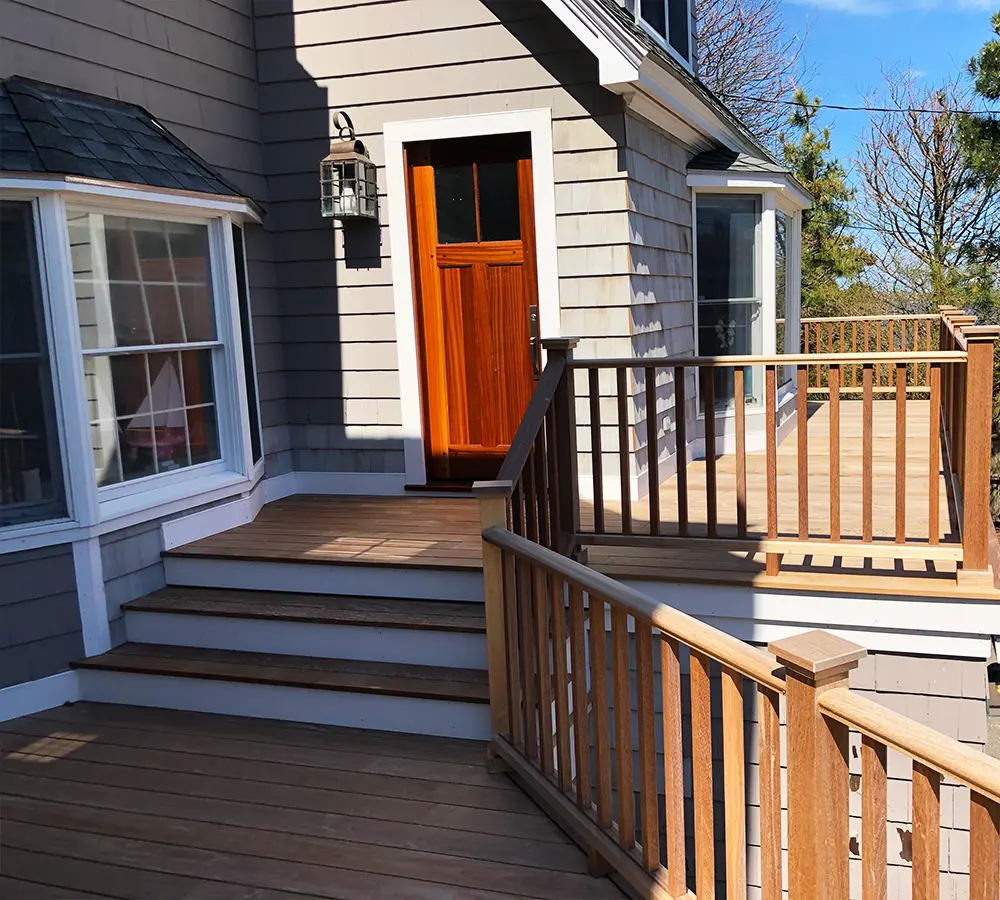 Backyard deck with white railing and garden view, creating a cozy, natural outdoor setting.