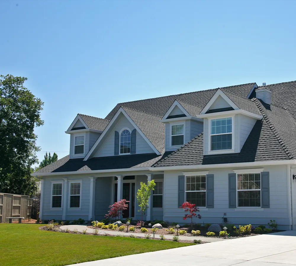 Modern home with fresh light blue exterior paint and landscaped front yard.