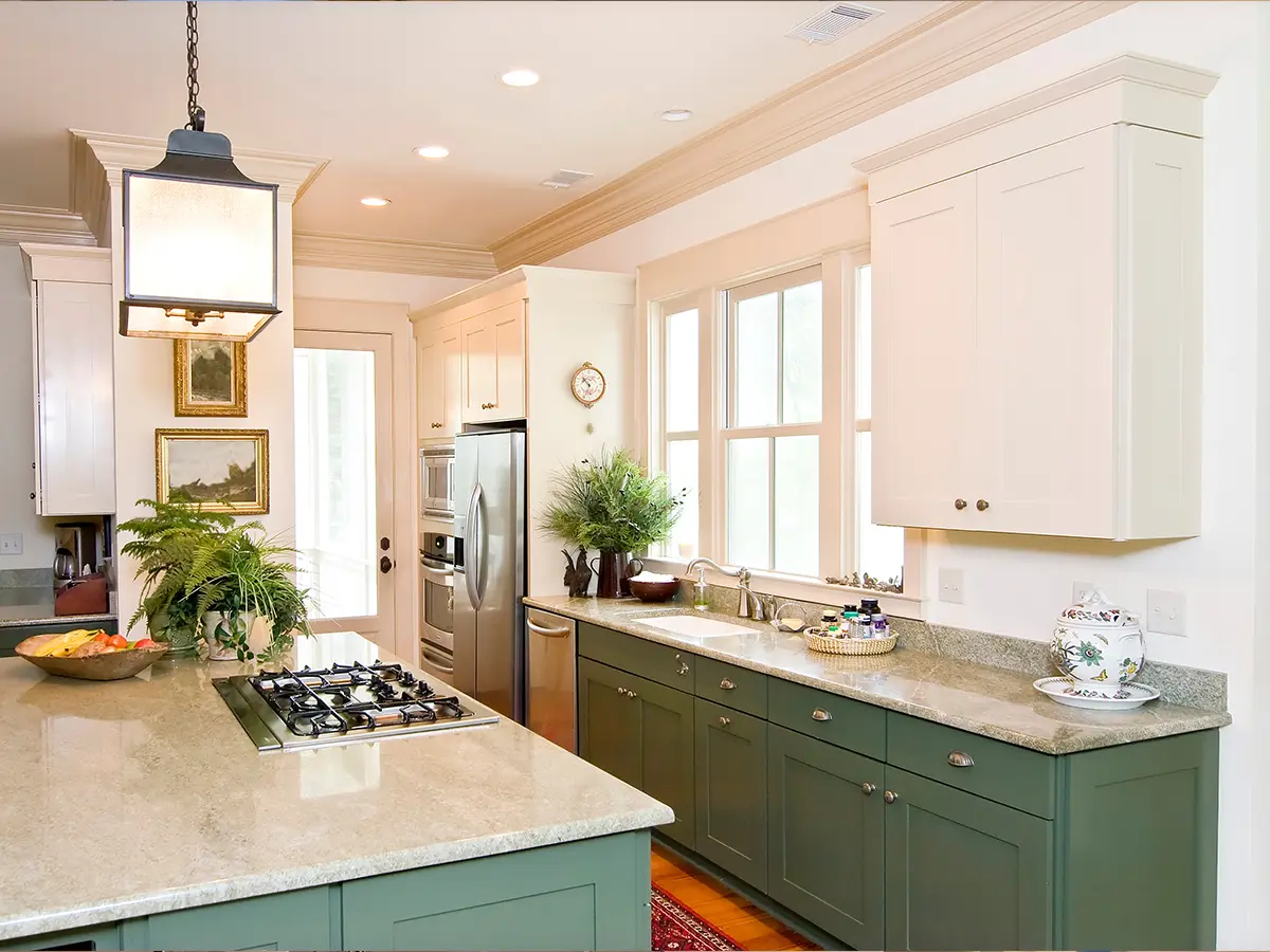 Stylish kitchen design with contrasting green and white cabinets, granite countertops, and stainless steel appliances for a fresh, inviting look.