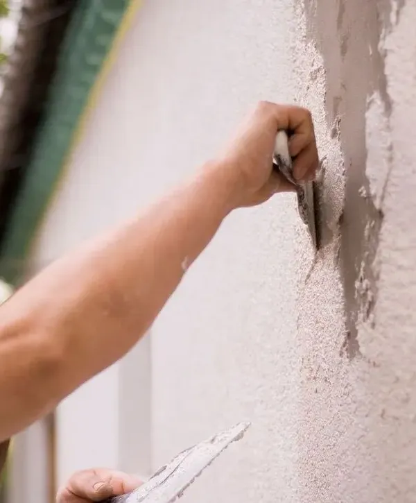 Worker on painting exterior site for a house